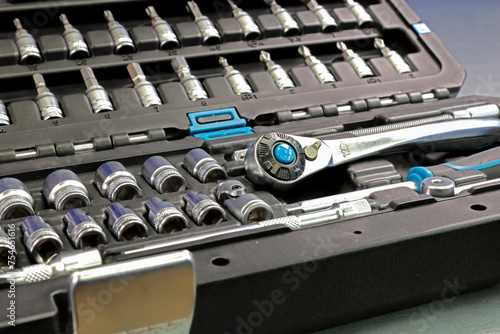 Universal tool box, tool kit closeup with set of hex, torx and screwdriver bits, and various sizes of ratchet wrench sockets photo