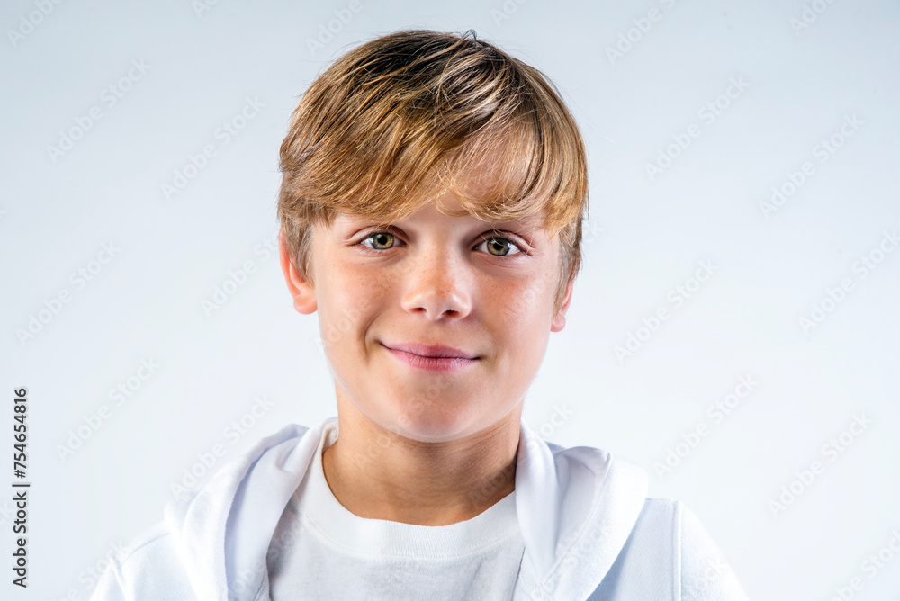 Close up portrait of a smiling preteen boy dressed in white Close up portrait of a smiling preteen boy dressed in white