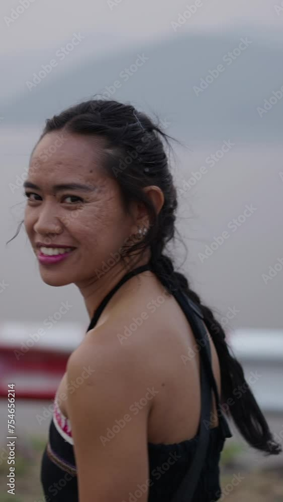 A woman smiles and looks towards the mountains A woman smiles and looks towards the mountains