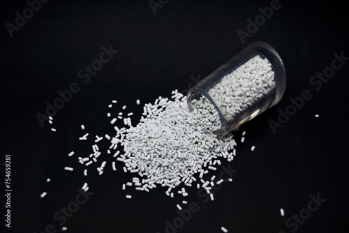 white masterbatch granules on a black background, this polymer is a colorant for products in the plastics industry