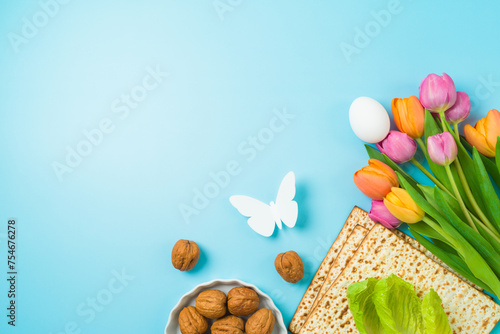 Jewish holiday Passover concept with matzah and  spring tulip flowers on blue  background. Top view, flat lay composition photo
