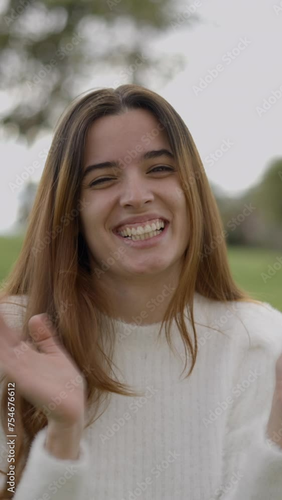 Young woman smiles and claps hands toward camera, close static view Young woman smiles and claps hands toward camera, close static view