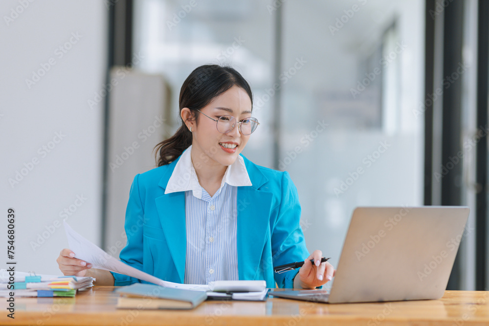Asian accounting woman working with document paper and laptop computer at table office, Financial and accounting woman concept. Asian accounting woman working with document paper and laptop computer at table office, Financial and accounting woman concept.