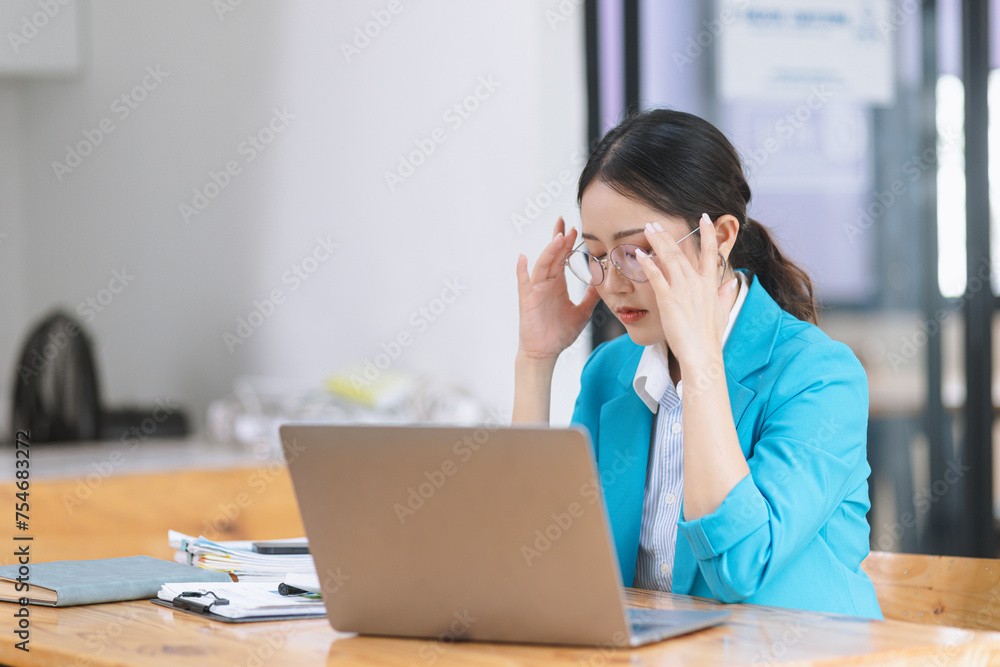 Asian businesswoman are stressed and tired from work sitting at desk in the office, feeling sick at work, stress from work. Asian businesswoman are stressed and tired from work sitting at desk in the office, feeling sick at work, stress from work.