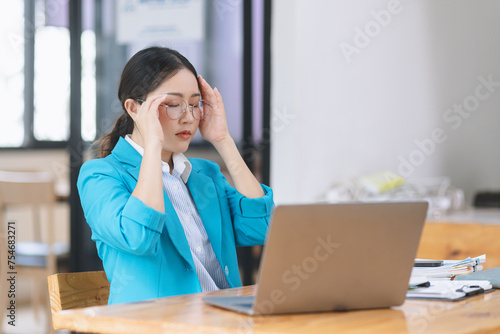 Asian businesswoman are stressed and tired from work sitting at desk in the office, feeling sick at work, stress from work. 