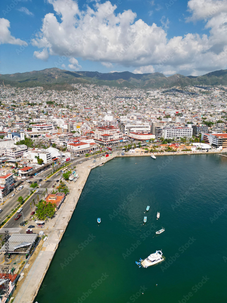 Vertical aerial snapshot highlighting the bustling streets of Acapulco's downtown area adjacent to the tranquil sea