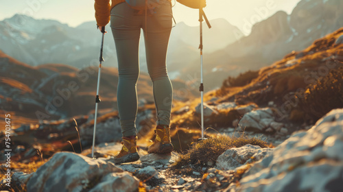 An image of a hiker from behind walking on a mountain trail, bathed in the golden light of the setting sun photo