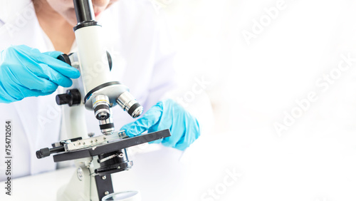 Scientists analyzing study data and evaluating microscope success for work shop. Health care researchers doing some research with dropper chemical testing in life science laboratory