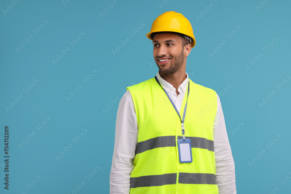 Engineer with hard hat and badge on light blue background, space for text Engineer with hard hat and badge on light blue background, space for text