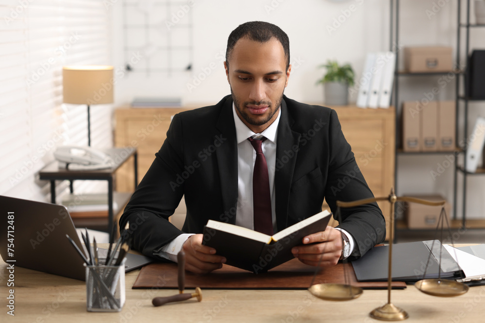 Serious lawyer reading book at table in office Serious lawyer reading book at table in office