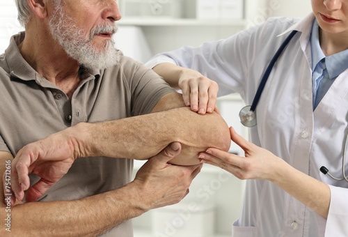 Photography Arthritis symptoms. Doctor examining patient's elbow in hospital