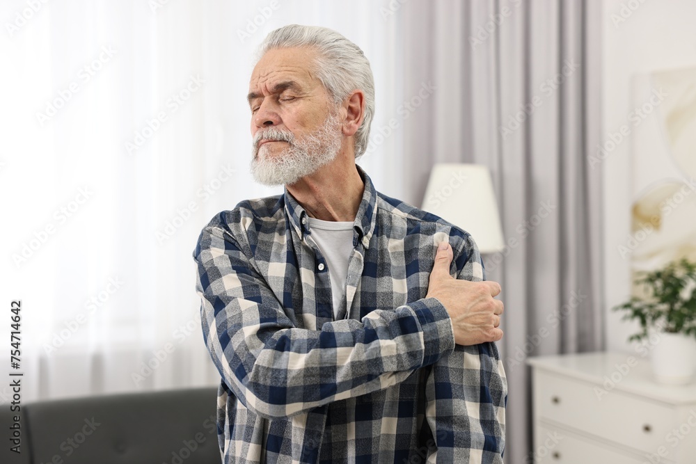 Arthritis symptoms. Man suffering from pain in shoulder at home Arthritis symptoms. Man suffering from pain in shoulder at home