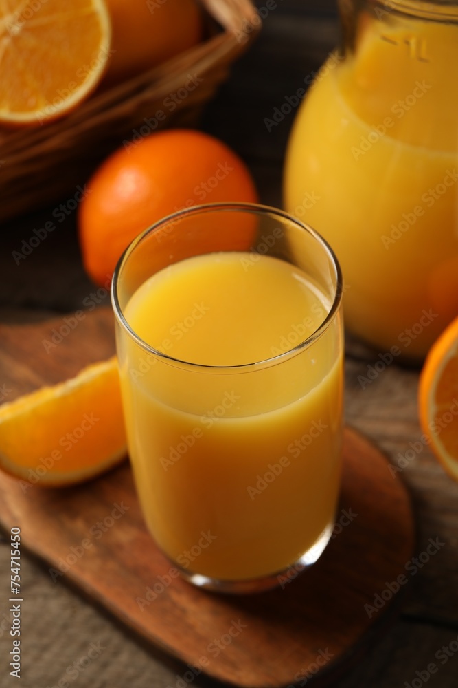 Tasty fresh oranges and juice on wooden table, closeup Tasty fresh oranges and juice on wooden table, closeup