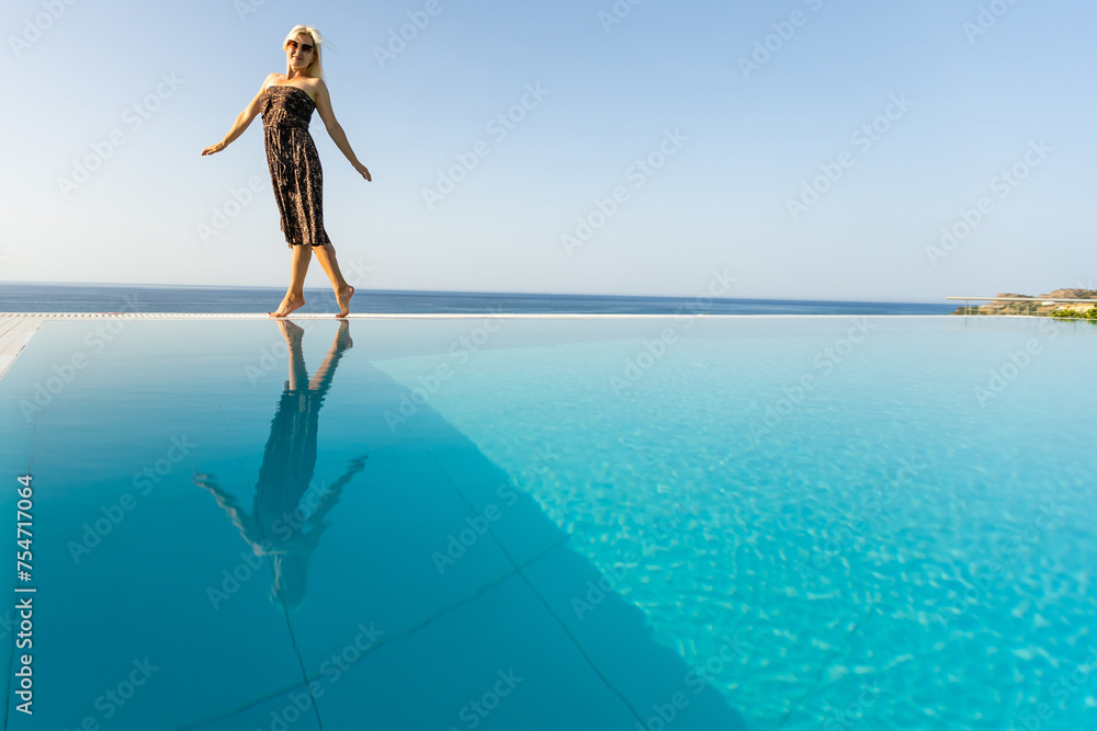 woman near the pool. By Swimming Pool On Travel Holidays Vacation. Beauty, Wellness, Lifestyle