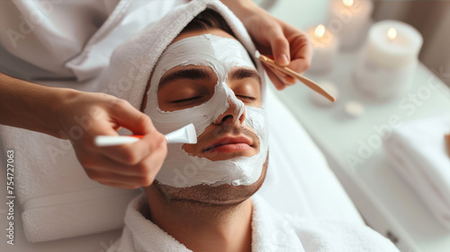 Beautiful young man with facial mask at spa salon, closeup