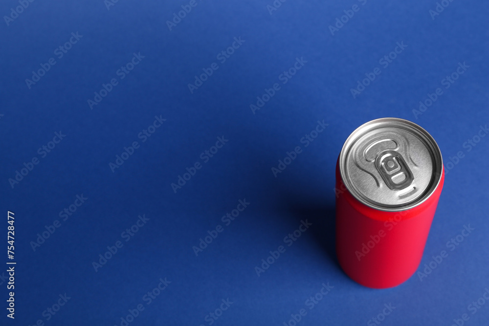 Energy drink in red can on blue background, above view. Space for text Energy drink in red can on blue background, above view. Space for text