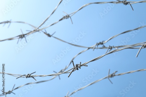 Metal barbed wire on light blue background