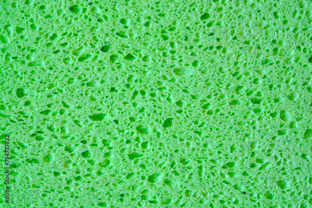 Green sponge with pores texture background for graphics. Close-up macro photo of household sponge tissue. Green sponge with pores texture background for graphics. Close-up macro photo of household sponge tissue.