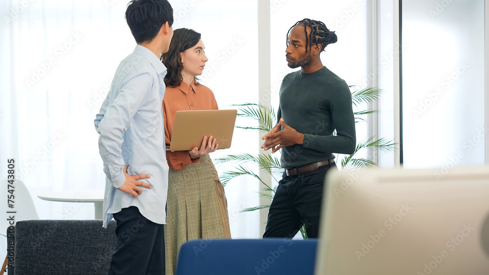 Fototapeta premium Multinational people talking while looking at laptop PC in the lobby. International business.