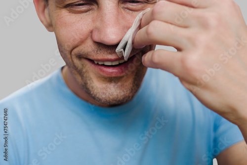 Happy smiling man sniffing teabag smell after end of virus illness. Aromatic revival: Recovering the lost sense of smell