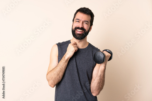 Caucasian sport man with beard making weightlifting over isolated background laughing © luismolinero