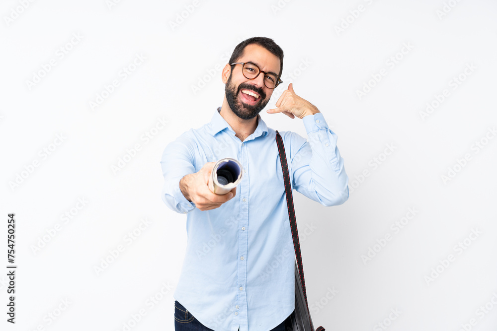 Young architect man with beard over isolated white background making phone gesture and pointing front Young architect man with beard over isolated white background making phone gesture and pointing front