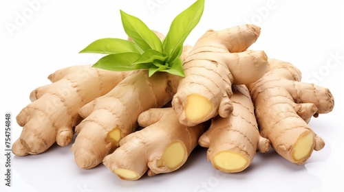 A pile of Ginger root with green mint leaves against a white backdrop
