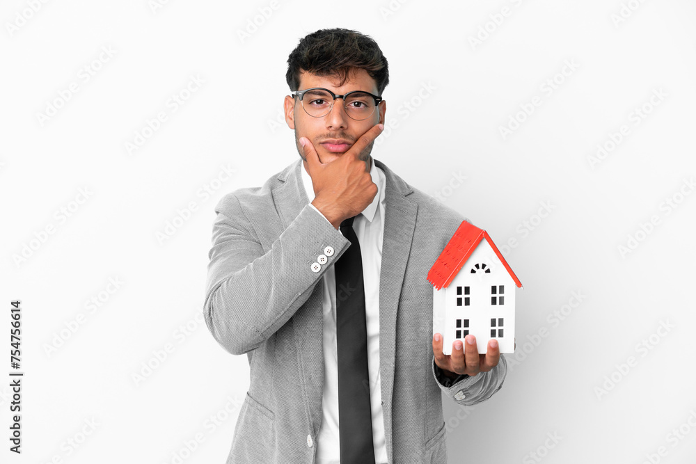 Business man holding a house isolated on blue background happy and smiling Business man holding a house isolated on blue background happy and smiling