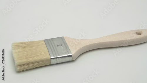 Slow motion panorama flat brush for paints on a white background.