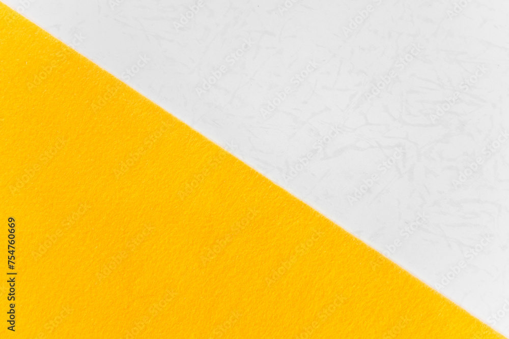 Two textured color paper with Yellow and white Overlap top view And split half of the image. Two textured color paper with Yellow and white Overlap top view And split half of the image.