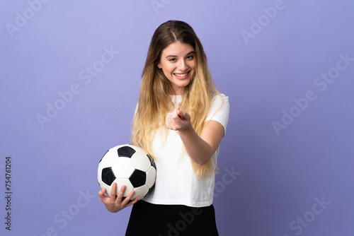 Young blonde football player woman isolated on purple background making money gesture © luismolinero