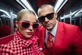 Elegant couple in stylish red outfits posing in modern subway
