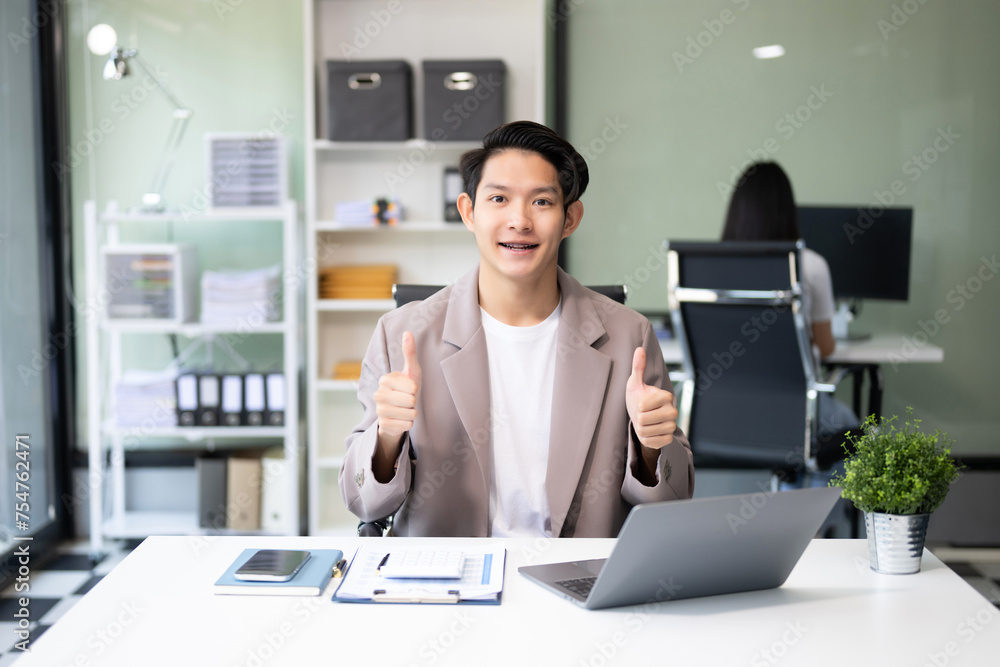 Young attractive Asian male office worker business suits smiling at camera Young attractive Asian male office worker business suits smiling at camera