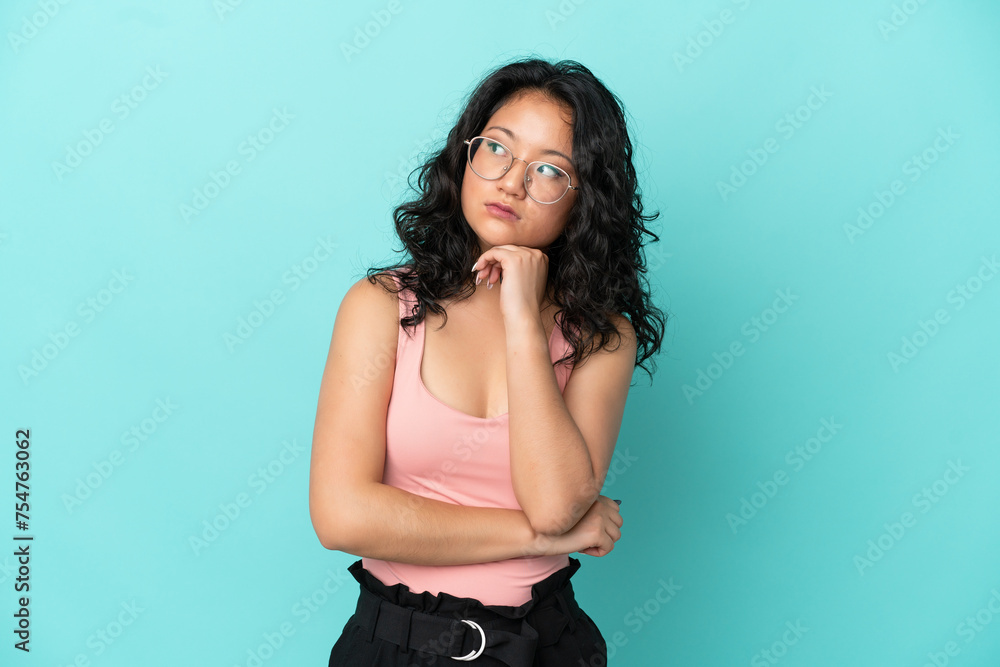 Young asian woman isolated on blue background with tired and bored expression Young asian woman isolated on blue background with tired and bored expression