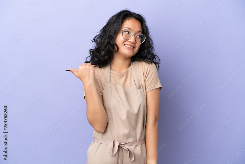 Restaurant asian waiter isolated on purple background pointing to the side to present a product Restaurant asian waiter isolated on purple background pointing to the side to present a product