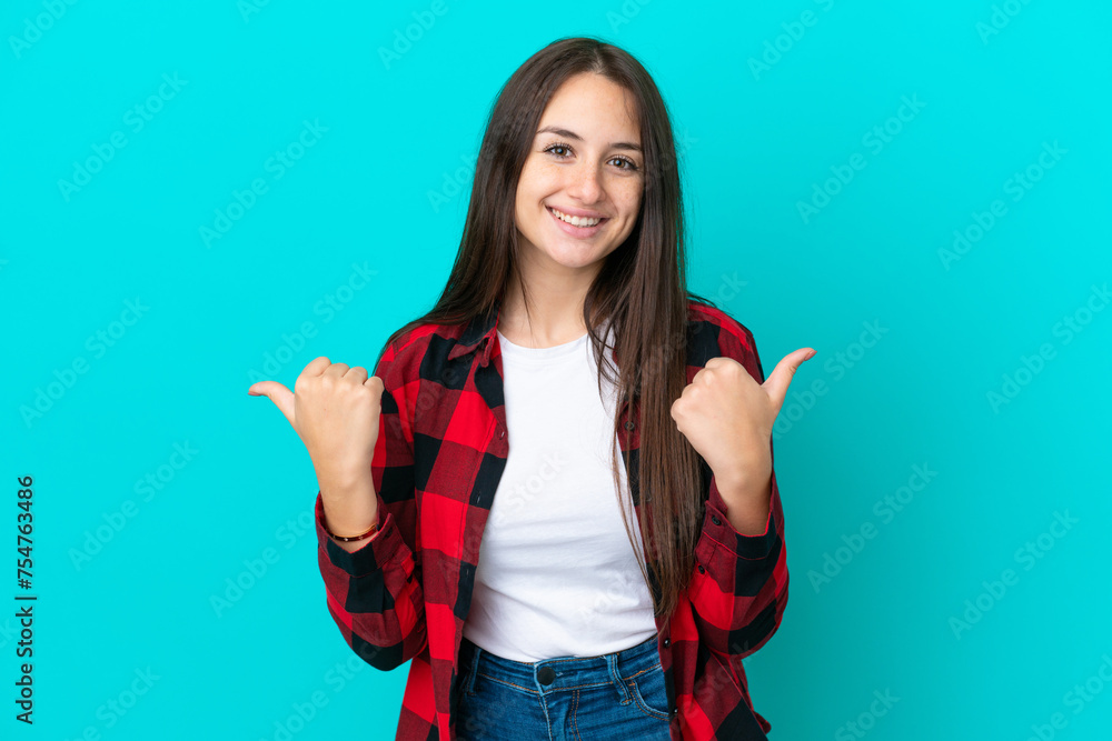 Young Ukrainian woman isolated on blue background with thumbs up gesture and smiling Young Ukrainian woman isolated on blue background with thumbs up gesture and smiling