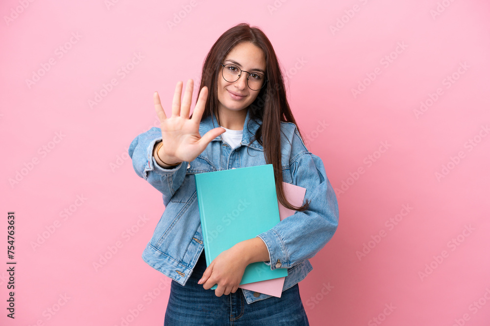 Fototapeta premium Young Ukrainian student woman isolated on pink background counting five with fingers