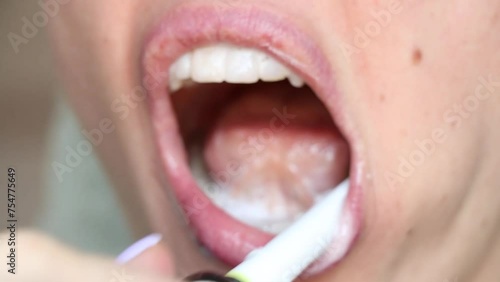 Girl brushing her teeth with an electric toothbrush close-up, dental care, no retouching photo