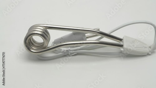 Slow motion panorama of travel immersion water heater on white background.