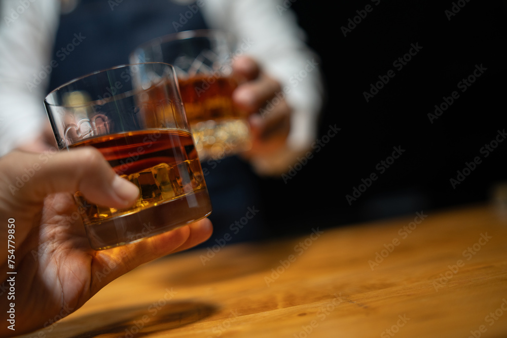 Bartender pours whiskey to customer in tavern