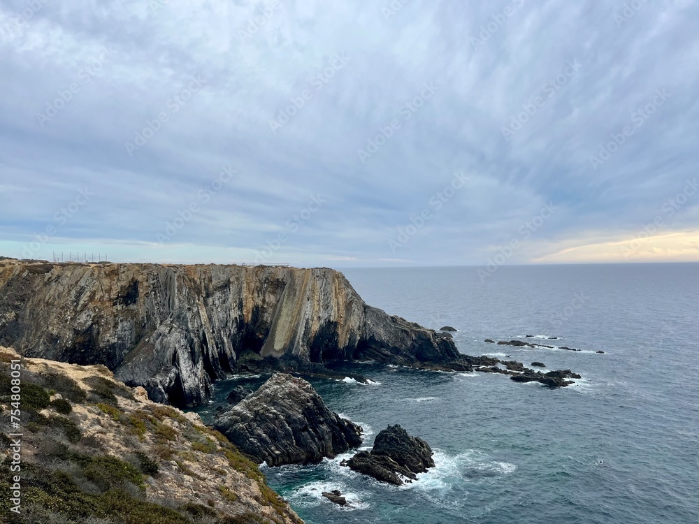 Fantastic rocky coast, cloudy sky, twilights time, ocean horizon Fantastic rocky coast, cloudy sky, twilights time, ocean horizon