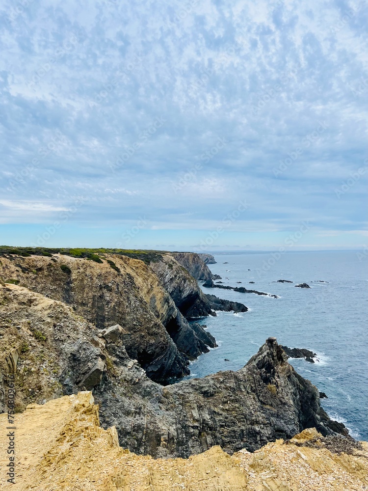 Fantastic rocky coast, cloudy sky, twilights time, ocean horizon Fantastic rocky coast, cloudy sky, twilights time, ocean horizon