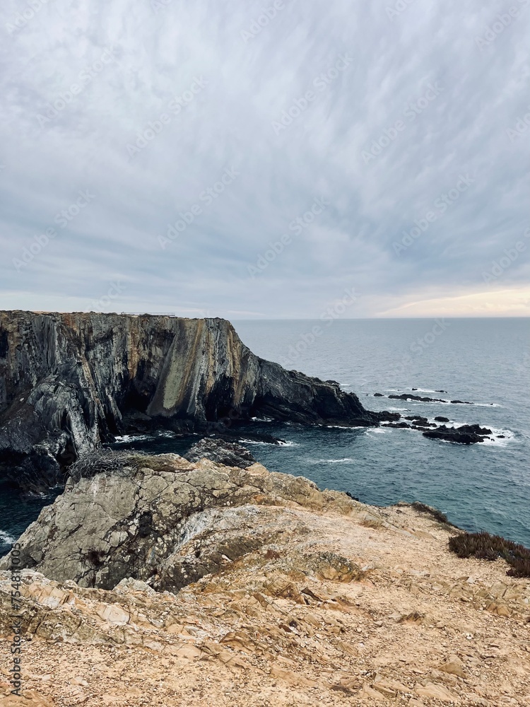 Fantastic rocky coast, cloudy sky, twilights time, ocean horizon