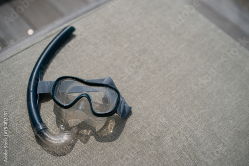 Snorkel and swimming mask lie on a gray pad background.