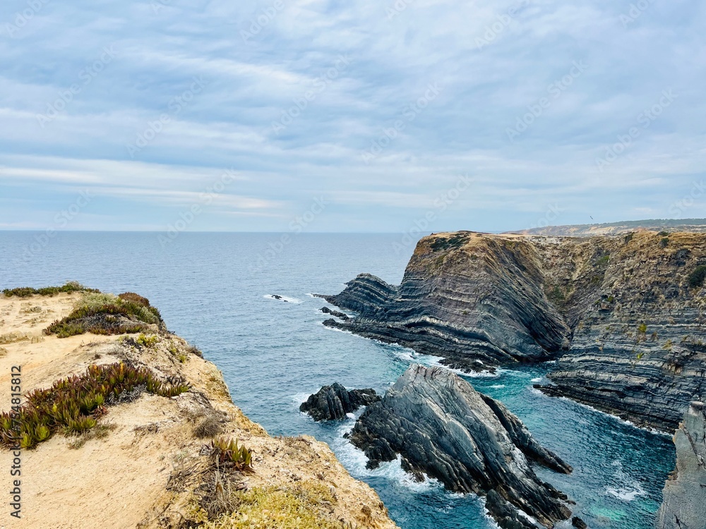 Fantastic rocky coast, cloudy sky, twilights time, ocean horizon