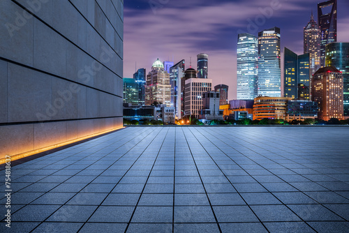 Empty square floor and modern city buildings at night in Shanghai
