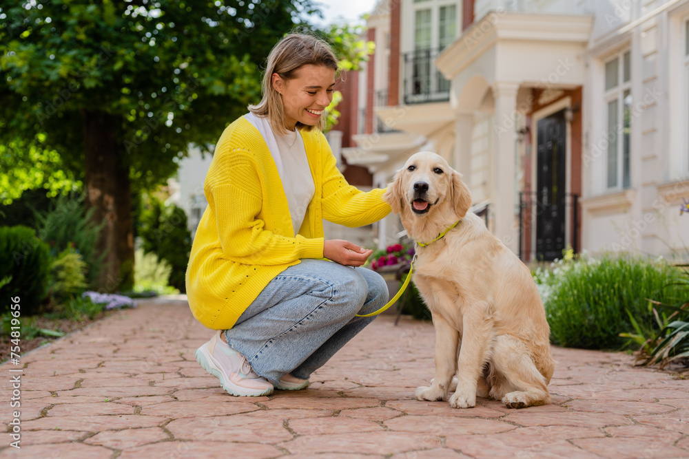 happy smiling woman in yellow sweater walking at her house with a dog golden retriever happy smiling woman in yellow sweater walking at her house with a dog golden retriever