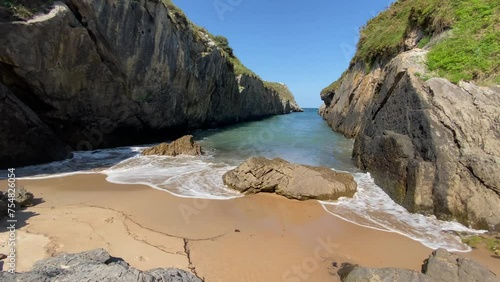 waves hitting rocks on a small beach