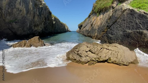 waves hitting rocks on a small beach