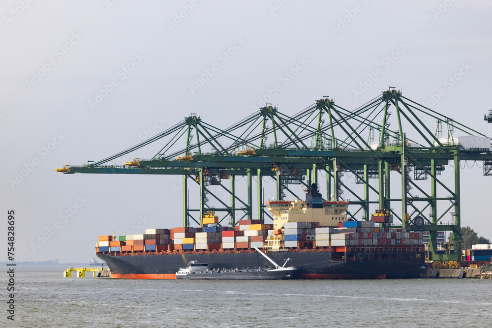 Giant container ship loading containers in the port